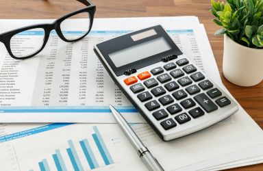 Calculator, Glasses, and Accounting Documents on a Desk