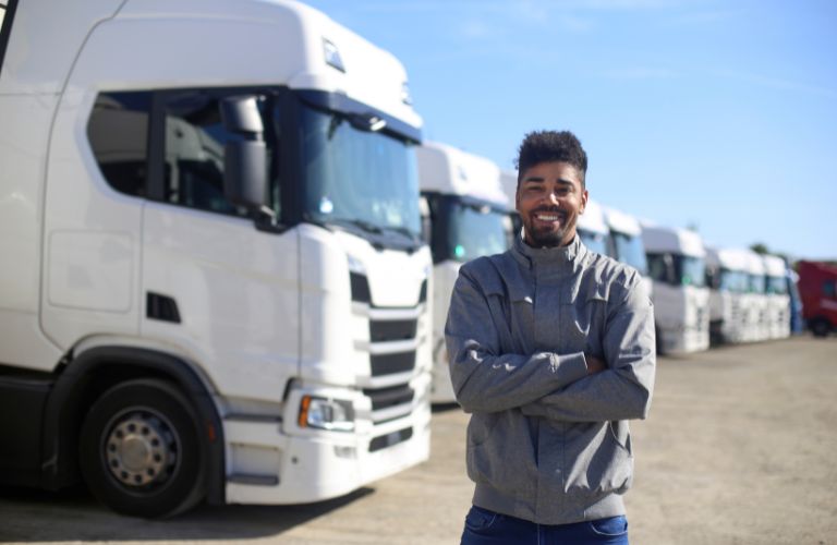 Truck Driver in Front of Line of White Trucks