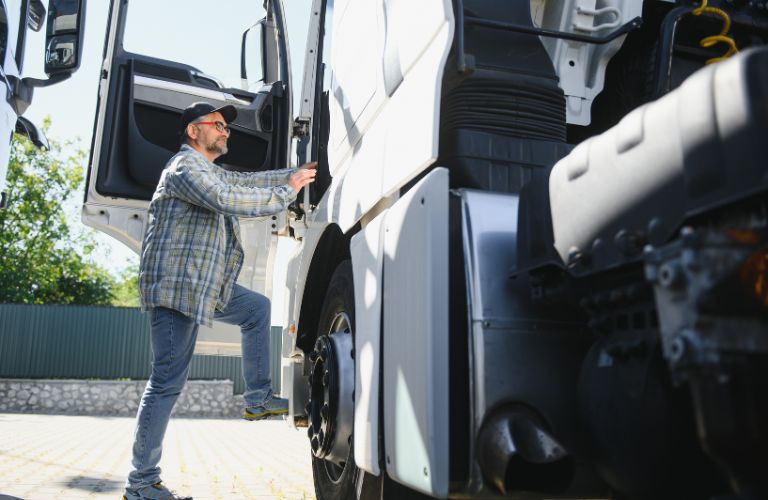 Man Climbing into a Semi Truck