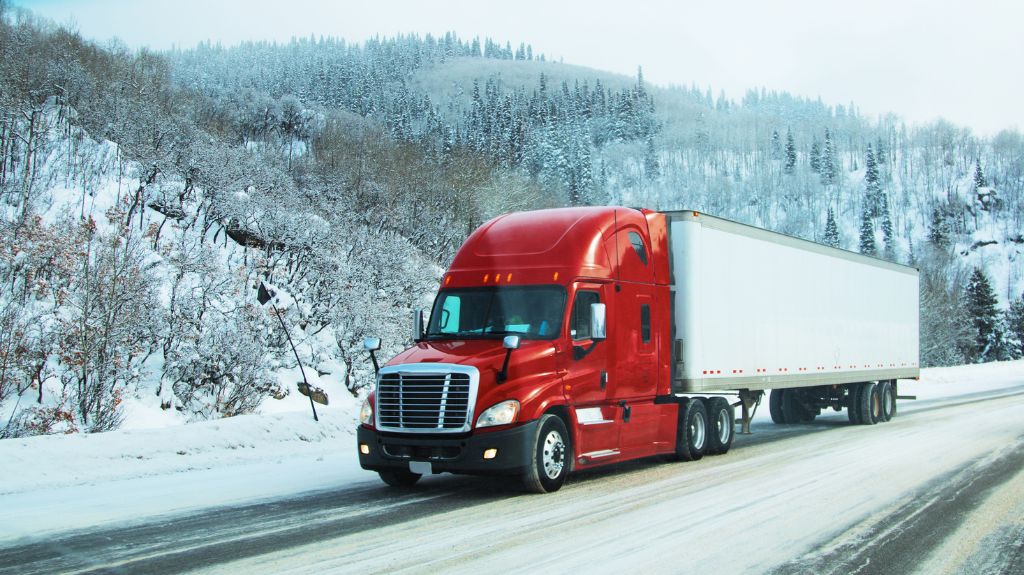 Red Semi Truck Driving on Snowy Highway