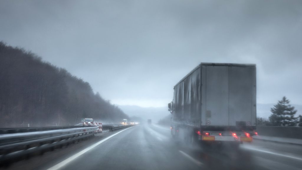 Semi Truck Driving on Wet Road in Rain