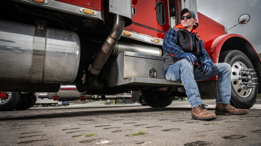 Truck Driver Sitting on the Step of a Commercial Truck